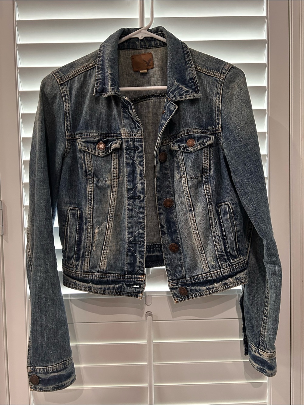 American Eagle Outfitters light blue denim jacket with brown leather patch